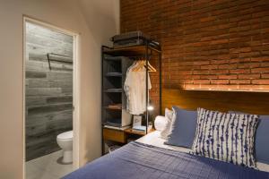 a bedroom with a bed and a brick wall at Cove W Suites in Jakarta