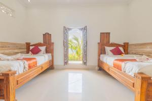 two beds in a room with a mirror at Manta Cottages with Sea View in Nusa Penida