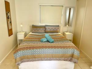 a bedroom with a large bed with two lamps at Rumah Pantai in Emu Bay