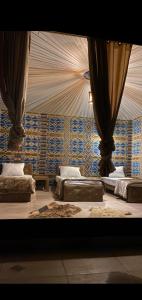 a room with three beds with curtains on the wall at Rum Under The Stars Camp in Wadi Rum