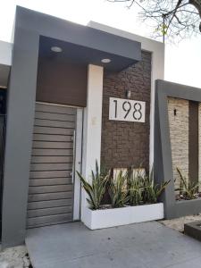 une maison avec un panneau indiquant un numéro sur son côté dans l'établissement Mono ambiente, Dpto. mediano, à Trinidad