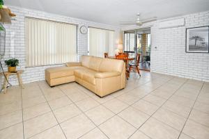 a living room with a couch and a table at Location is Everything - Shops, Beaches, Views ZG3 in Caloundra