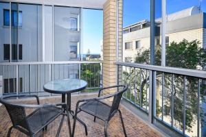 un patio con 2 sillas y una mesa en el balcón en Location is Everything - Shops, Beaches, Views ZG3, en Caloundra