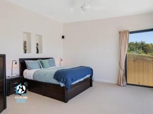 a bedroom with a bed and a window at Absolute Water Frontage w/ Jetty + Boat Ramp in Hindmarsh Island