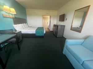 Habitación de hotel con cama y sofá en Howard Johnson by Wyndham Galveston en Galveston