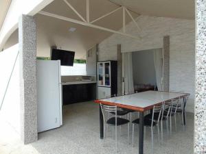 cocina con mesa, sillas y nevera en Conchal Maquito House, en Brasilito