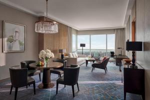 a living room with a couch and a table and chairs at InterContinental Hanoi Landmark72 by IHG in Hanoi