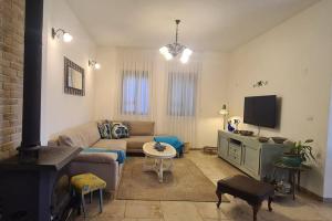 a living room with a couch and a tv at בית לוי in Dishon