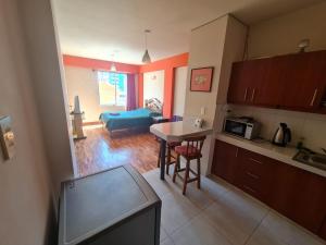 a kitchen and a living room with a table at Lhamourai Living Apartments in La Paz