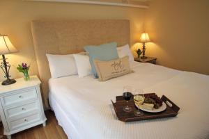 a tray with wine glasses and a plate of food on a bed at The Kennebunk Inn in Kennebunk