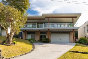 une maison avec un balcon au-dessus dans l'établissement Palm Breeze, à Forster