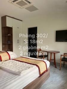 Snu Motel - Cao Bằng في كاو بانغ: غرفة نوم بسريرين وطاولة وتلفزيون