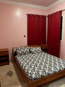 um quarto com uma cama e uma cortina vermelha em salamappart em Agadir