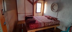 a small bed in a room with a clock on the wall at Ekas beach floating room and restaurant in Ekas