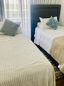 two beds sitting next to each other in a bedroom at Alta Vista Las Condes in Santiago