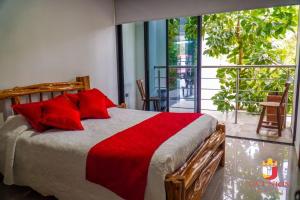 库里蒂Hotel la Union的一间卧室，有一张带红色枕头的床和一扇窗户