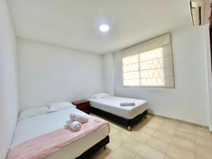 een slaapkamer met 2 bedden en een raam bij Excelente apto cerca al mar in Cartagena