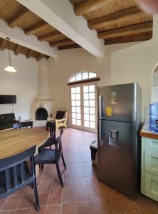 a kitchen with a stainless steel refrigerator and a table at Casa Colonial "Dulce Hogar" in Baños