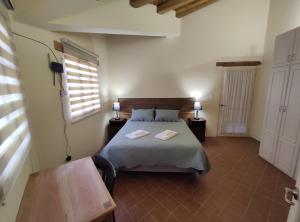 Schlafzimmer mit einem Bett, einem Tisch und einem Fenster in der Unterkunft Casa Colonial "Dulce Hogar" in Baños