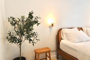 a bedroom with a plant next to a bed and a lamp at Beachfront Deluxe pool access room one-minute walk to Wonnapha beach in Bangsaen