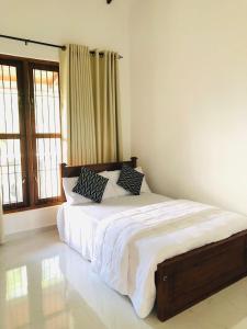 a bedroom with a bed with white sheets and pillows at Bluminz Homes in Katugastota