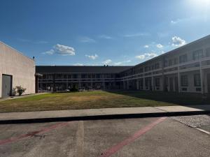 un gran edificio con un gran patio delante en Baymont by Wyndham Port Arthur - Groves Area, en Port Arthur