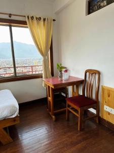 a room with a table and a chair and a window at Kathmandu View Hotel in Kathmandu