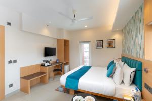 a hotel room with a bed and a desk at Cozzet Victoria Hotel in Bhubaneshwar