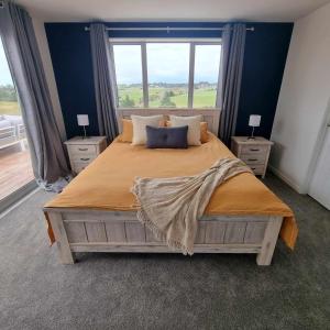 sypialnia z dużym łóżkiem i dużym oknem w obiekcie Brand new holiday home in Snells Beach w mieście Snells Beach