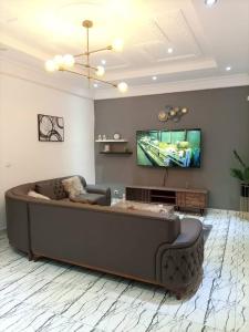 a living room with a large couch and a flat screen tv at Appartement chic & classe in Pointe-Noire