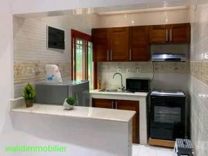 a kitchen with a sink and a stove top oven at Appartement chic & classe in Pointe-Noire