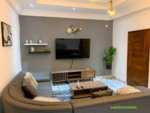 a living room with a couch and a flat screen tv at Appartement chic & classe in Pointe-Noire