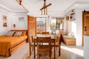 a bedroom with a bed and a table and chairs at Casa Talisay in General Luna