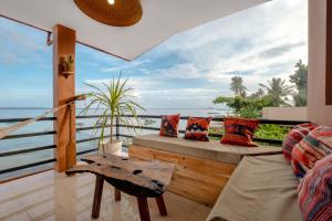 a balcony with a bed and a view of the ocean at Casa Talisay in General Luna