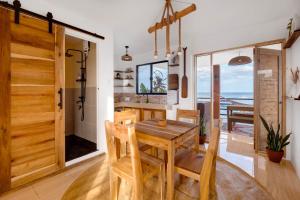 a kitchen and dining room with a wooden table and chairs at Casa Talisay in General Luna
