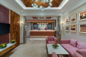 um átrio com sofás cor-de-rosa e uma sala de espera em Cozzet Victoria Hotel em Bhubaneshwar