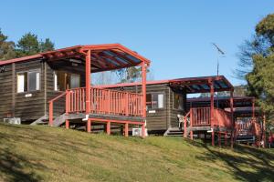 a log cabin on a hill with a house at Blackheath Glen Tourist Park in Blackheath