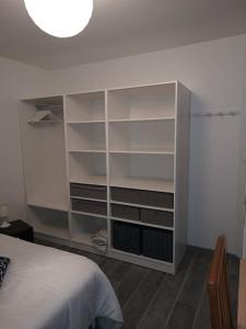 um quarto com uma cama e um armário branco em Chez Frédéric em Tomblaine