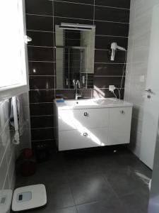 bagno con lavandino bianco e specchio di Chez Frédéric a Tomblaine