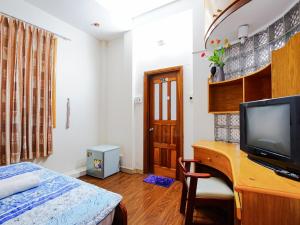 a bedroom with a desk with a television and a bed at AuLe Dorm Room in Ho Chi Minh City