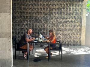 a man and a woman sitting at a table at Saffron Robes Living in Hikkaduwa