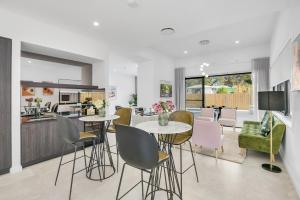 a kitchen and living room with tables and chairs at Luxurious Lakeside Oasis in Morisset East