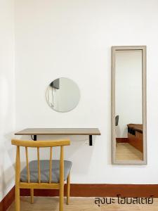 a table with a chair and a mirror at ลุงนะ โฮมสเตย์ ปางอุ๋ง แม่ฮ่องสอน in Ban Huai Makhuea Som