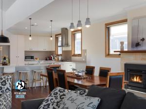 a kitchen and living room with a couch and a fireplace at Luxury Waterfront Holiday Home - Bring the Boat! in Hindmarsh Island