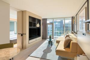 a living room with a couch and a large window at Andaz Seoul Gangnam in Seoul