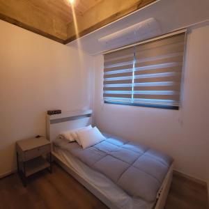 a small bedroom with a bed and a window at Joohane Jejudo House in Jeju