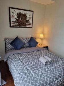 a bedroom with a large bed with blue pillows at Casa REYNA at KASARA Urban Residences in Manila