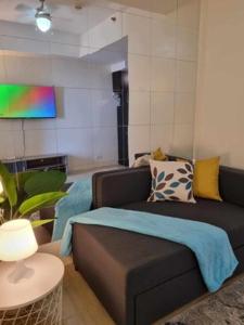a living room with a couch and a table at Casa REYNA at KASARA Urban Residences in Manila +25 photos