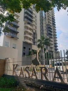 una señal frente a un edificio alto en Casa REYNA at KASARA Urban Residences, en Manila