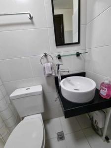 Casa REYNA at KASARA Urban Residences في مانيلا: حمام به مرحاض أبيض ومغسلة